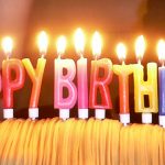 케이크 위에 생일 축하 문구 모양의 촛불이 켜진 모습